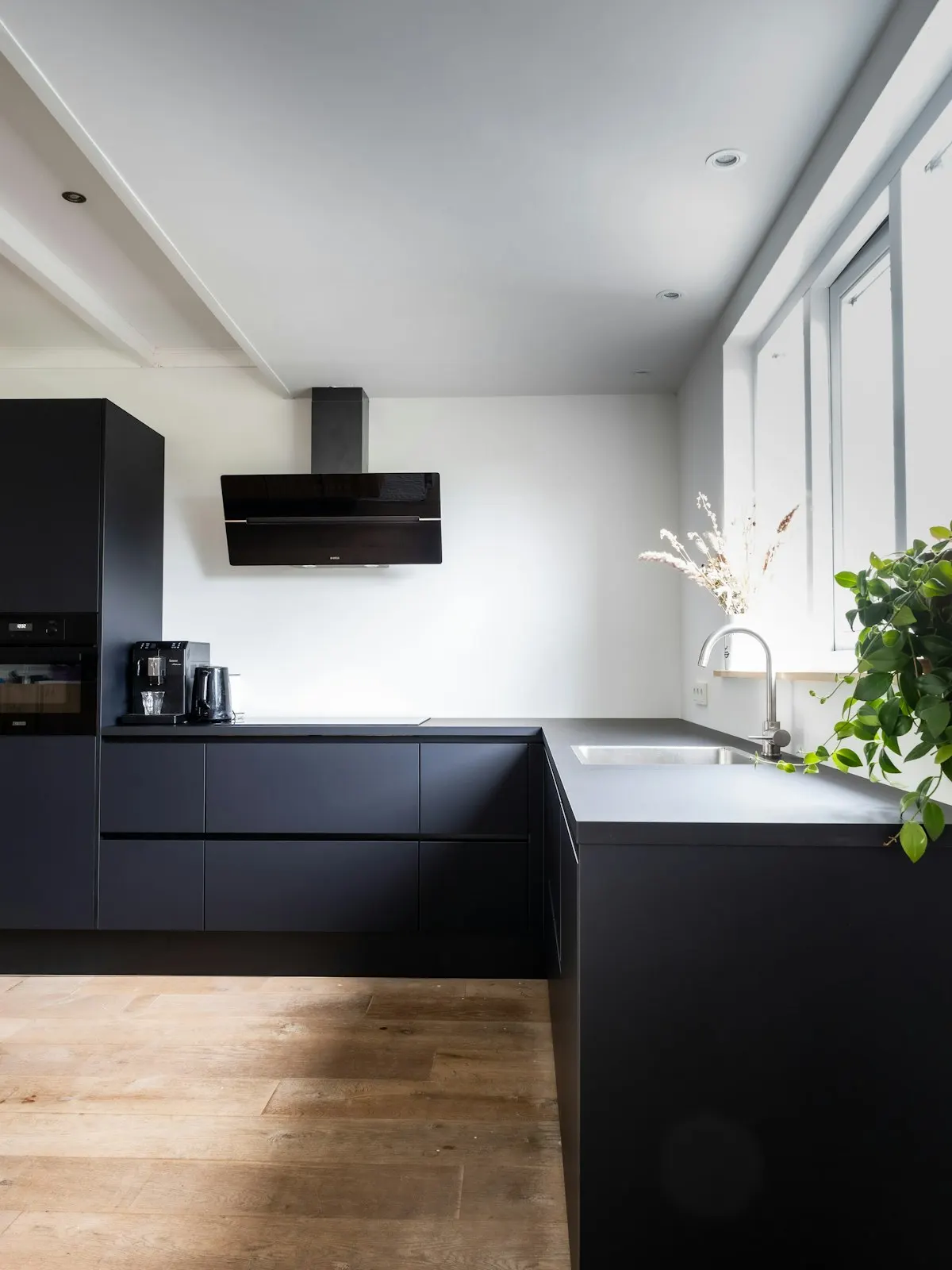 Dark kitchen worktop beside a bright window