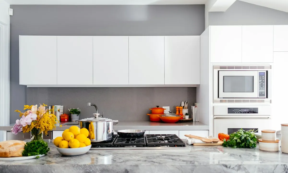 White kitchen cabinets above a worktop and cooking area
