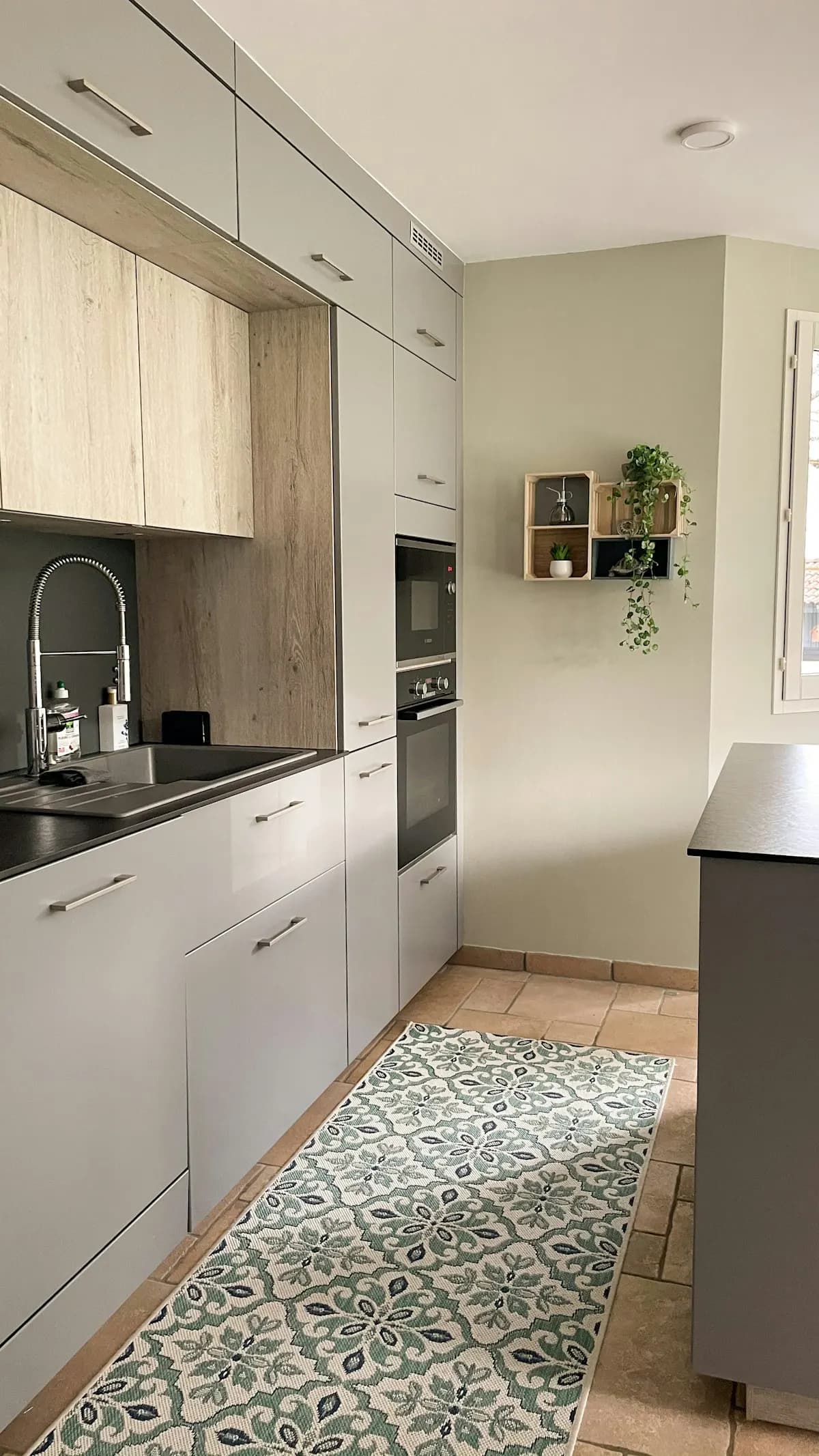 Narrow kitchen with white cupboards and a dark worktop