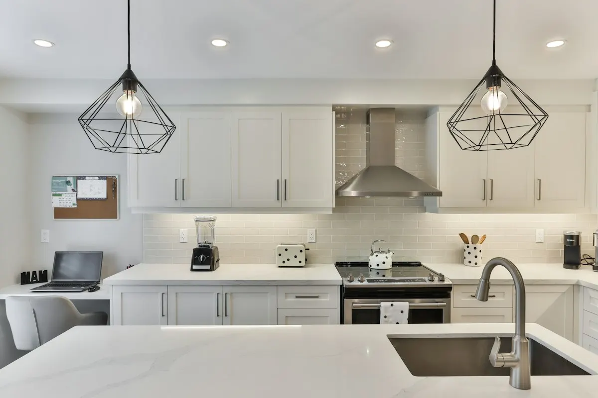 White kitchen sink beneath pendant lights