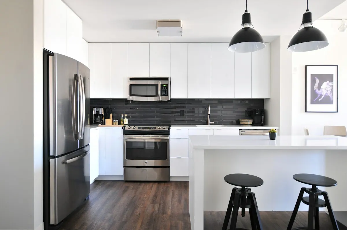 White kitchen with a breakfast counter and two stools